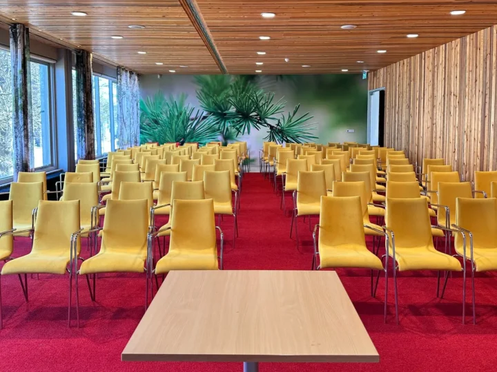 Zaal met rijen gele stoelen die gereinigd moeten worden